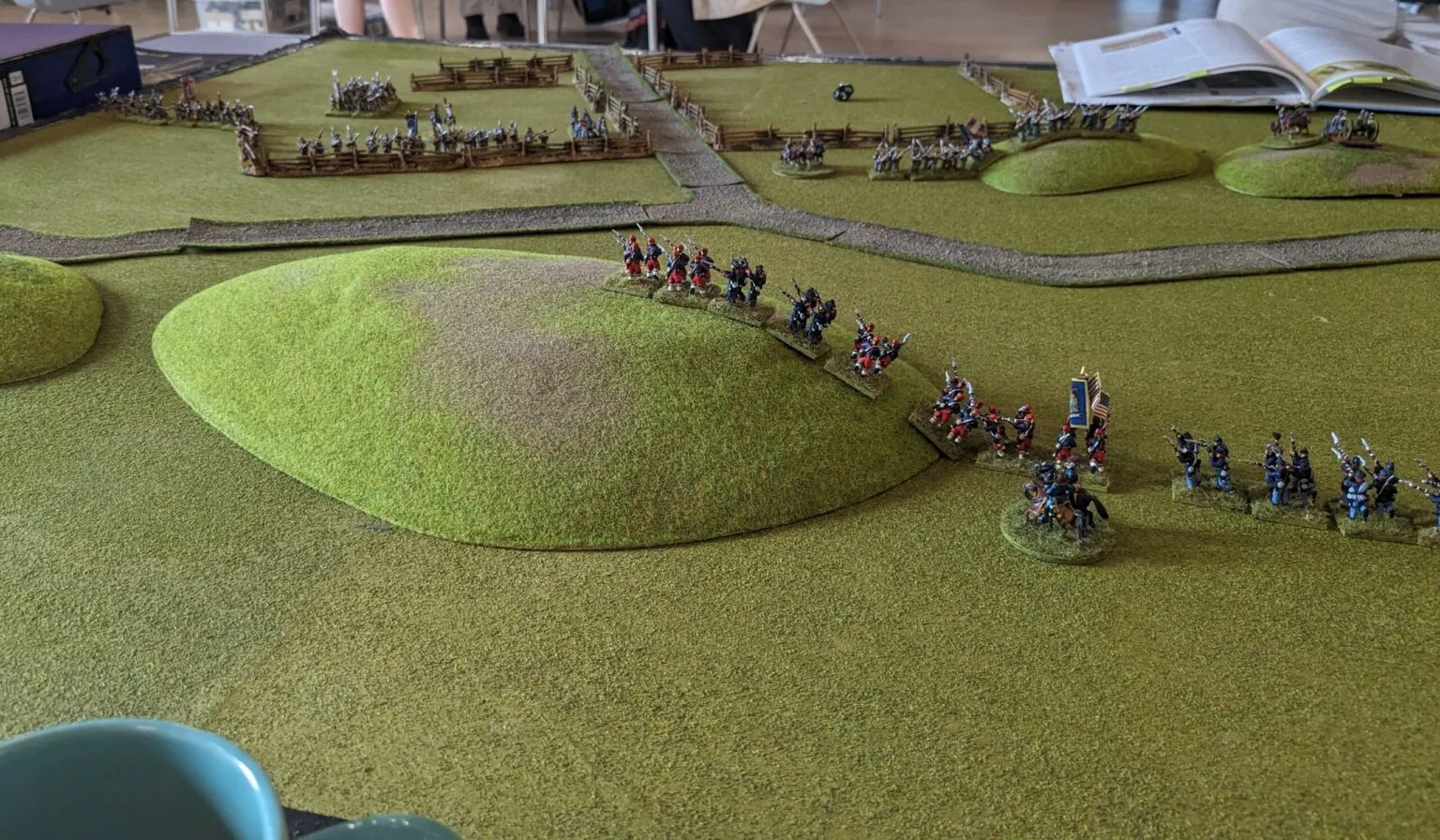 Union brigades deploying into line along a fenced road, Confederate forces holding the hills in the background