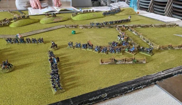 Union forces advancing in strength along the road junction, Confederate brigades holding the fenced fields